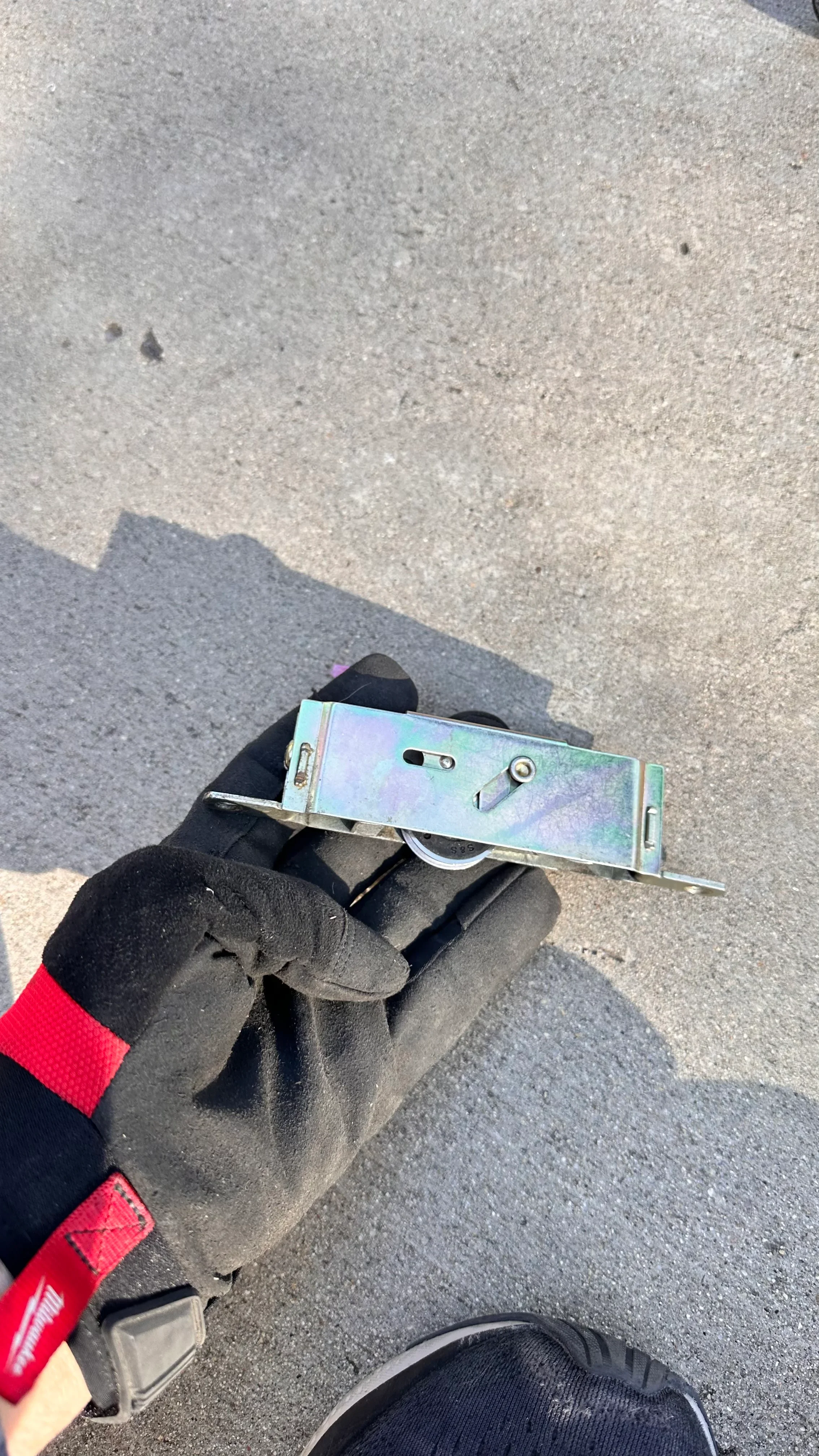 Close-up of technician holding repaired commercial door closer with chrome finish
