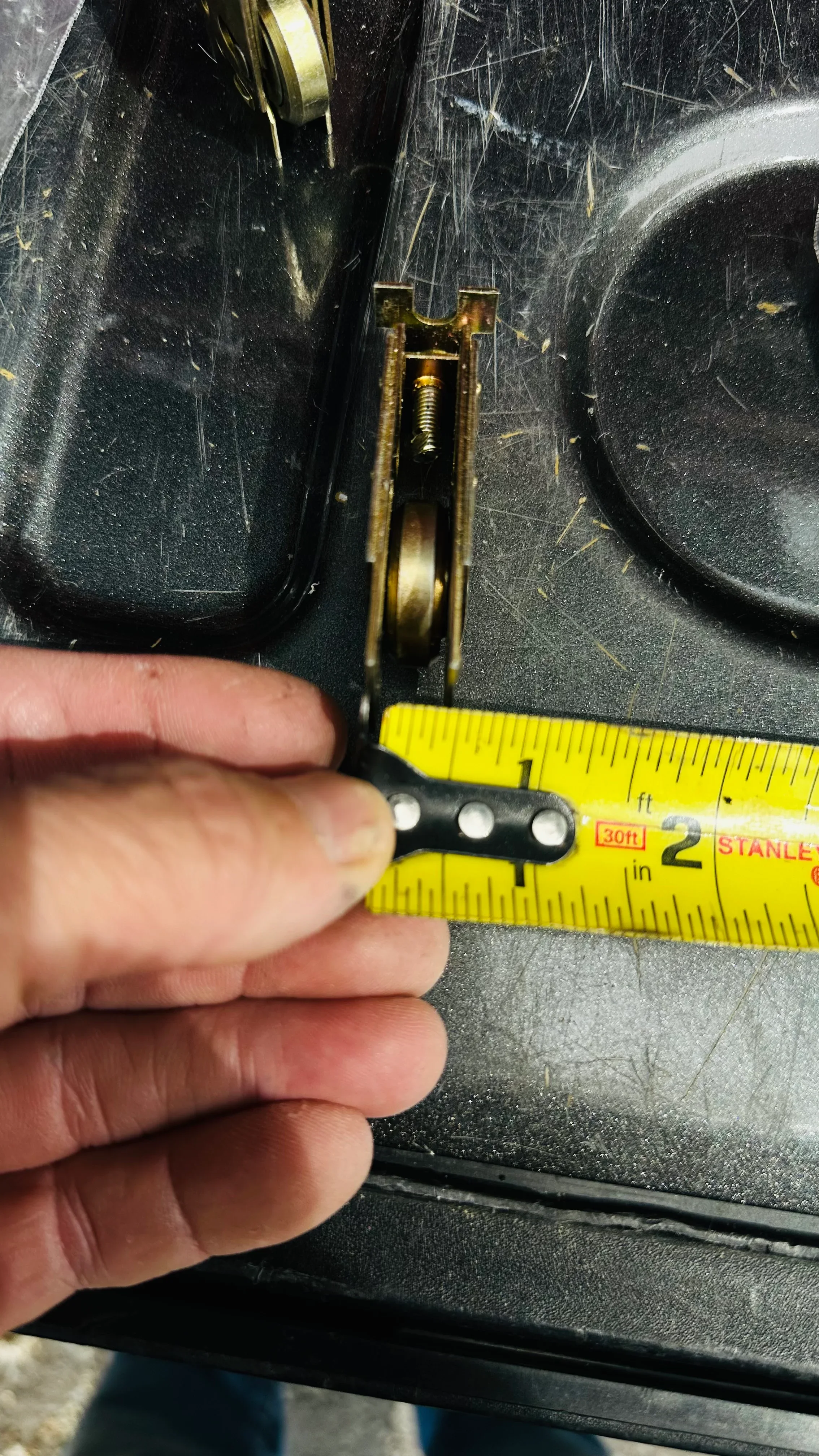 Door hinge hardware being measured with tape measure during inspection